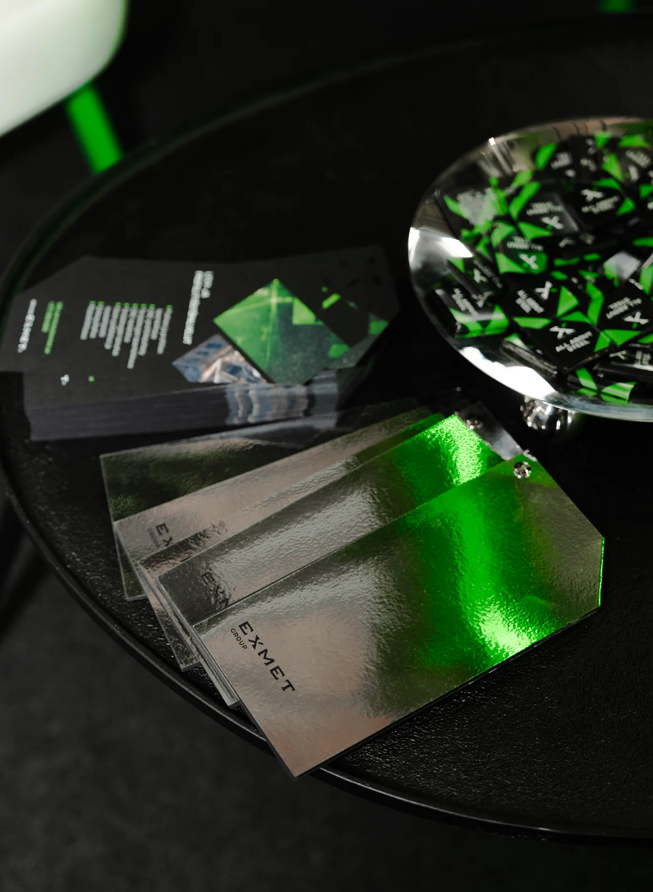 Exmet business cards and sweets on a dark table