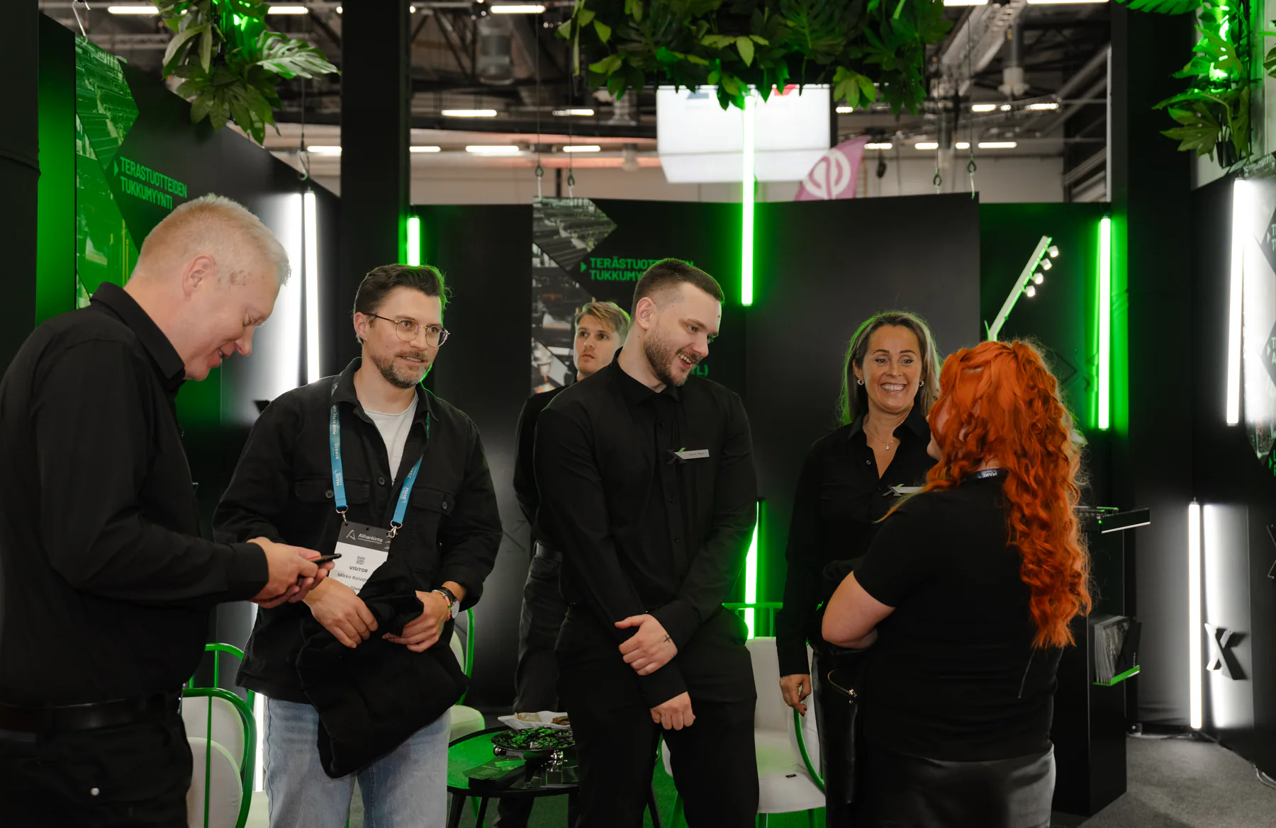 Exmet team laughing with visitors inside the stand
