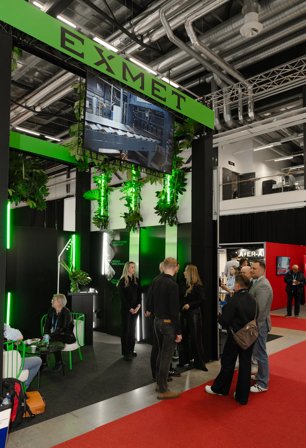 Corner of the Exmet stand with visitors on the red carpet