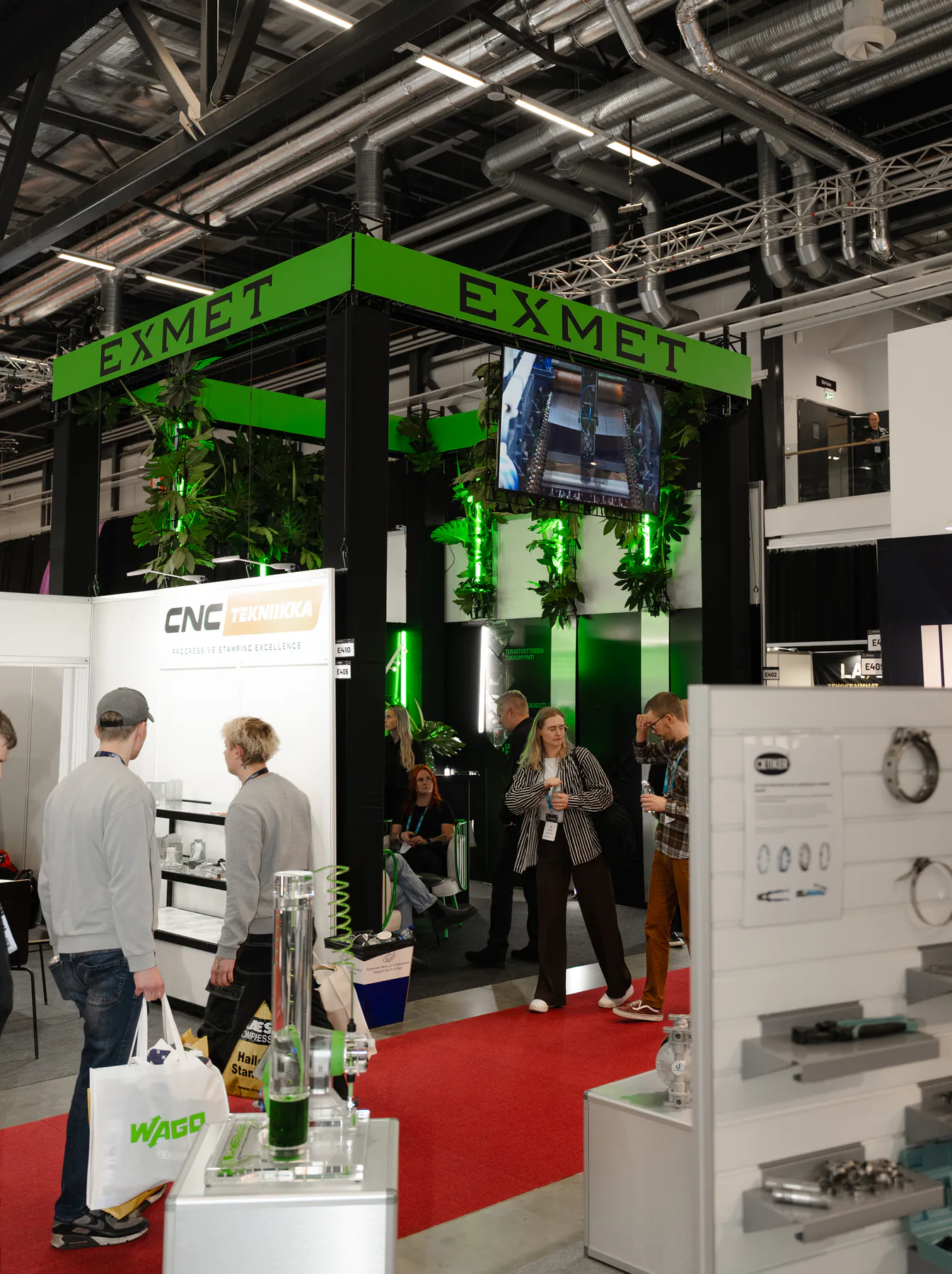 Visitors passing the Exmet stand in the exhibition aisle