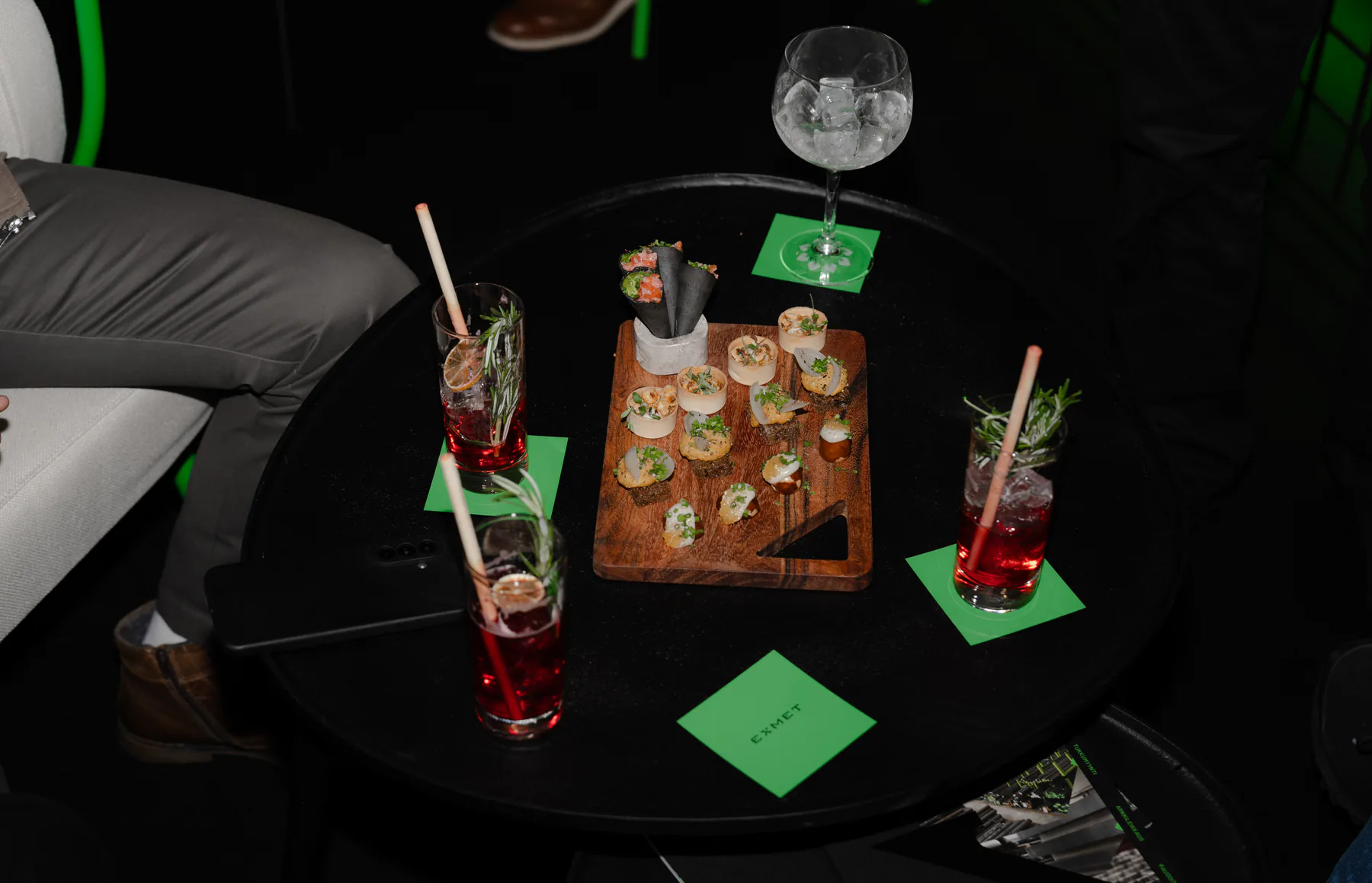 Table with drinks and small bites on Exmet napkins, seen from above