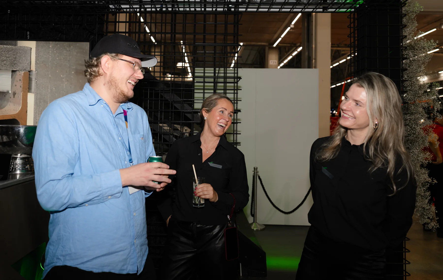 Visitor laughing with two Exmet team members at the stand
