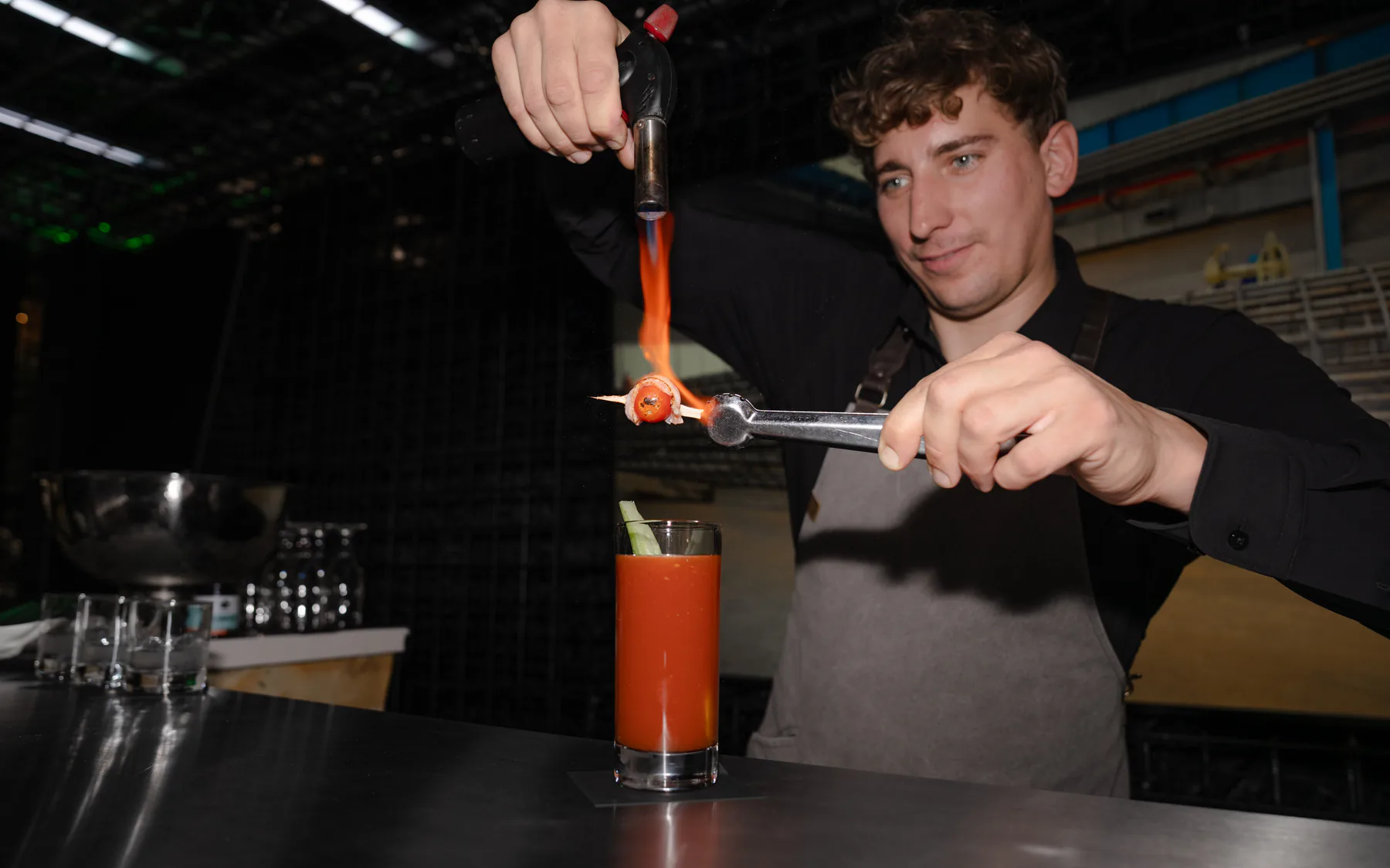 Bartender flaming a garnish over a drink