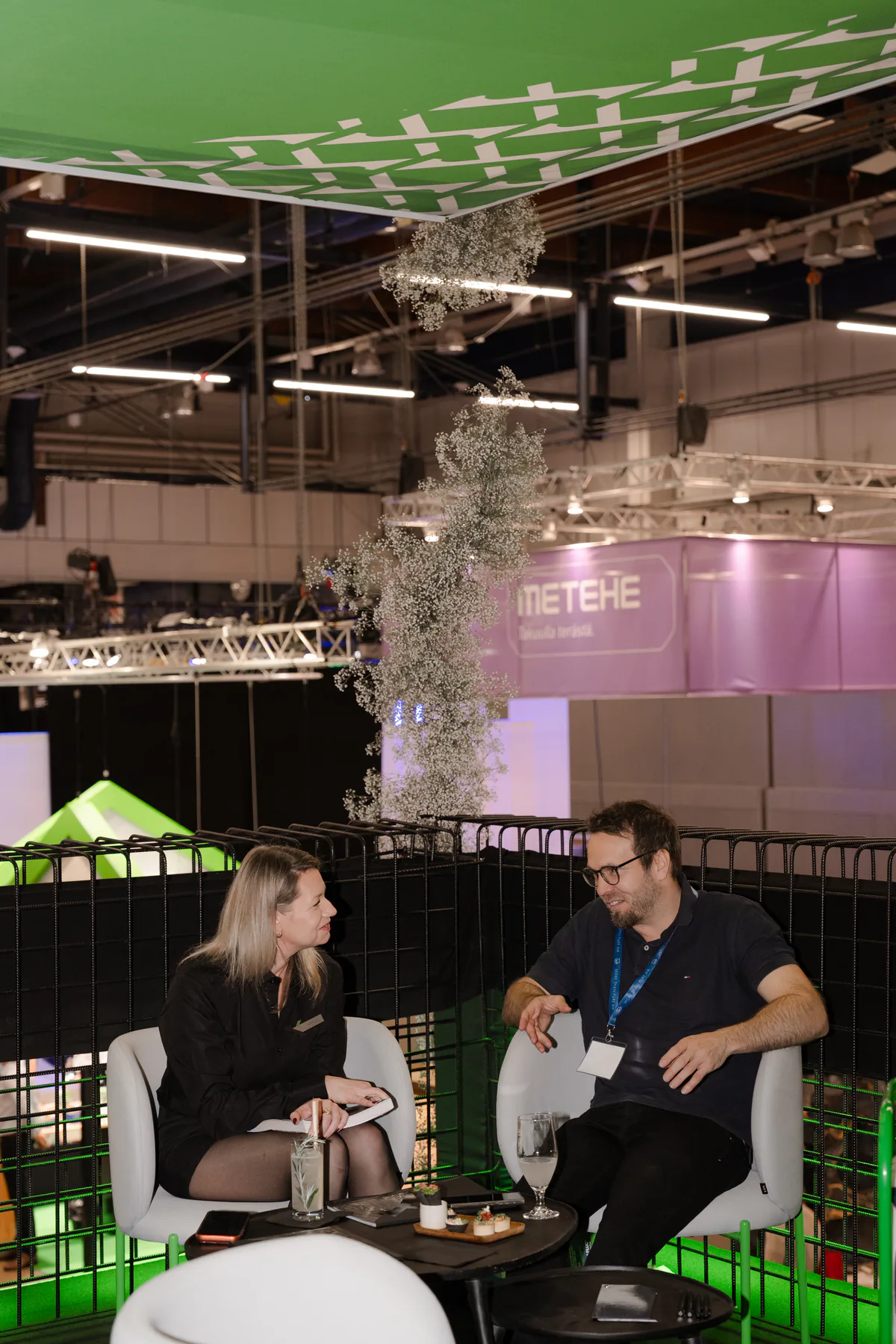 Two people in conversation on the upper level of the stand